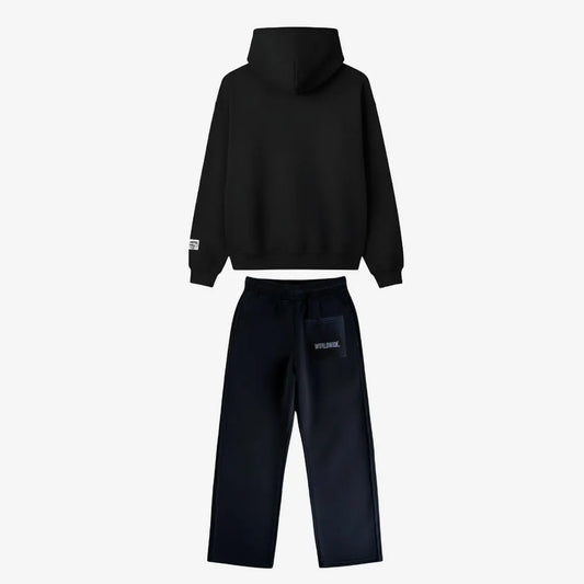 Back view of the full CELESTIC Black Basic Tracksuit set laid flat on a white background. This premium heavyweight black cotton fleece ensemble features an oversized zip-up hoodie with a structured hood and matching relaxed straight-leg sweatpants with white 'WORLDWIDE.' embroidery on the back pocket.