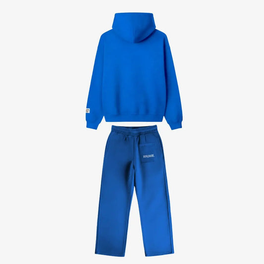 Back view of the CELESTIC Blue Basic Tracksuit laid flat on a white background. Premium heavyweight blue cotton fleece set showing a clean minimalist hoodie back, structured hood, and matching sweatpants featuring white 'WORLDWIDE' embroidery on the back pocket.