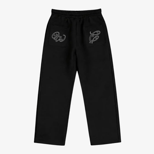 Black oversized tracksuit sweatpants back view laid flat on a white background. The premium heavyweight cotton fleece pants feature an elasticated waistband and custom white outline logo embroidery with star accents on both back pockets.