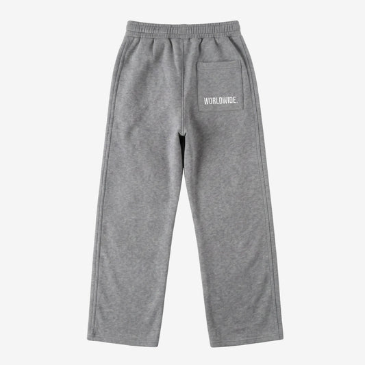 Back view of the CELESTIC Grey Basic sweatpants laid flat on a white background. These premium heavyweight grey cotton fleece pants feature a relaxed straight-leg silhouette and a back pocket with prominent white 'WORLDWIDE' logo embroidery.