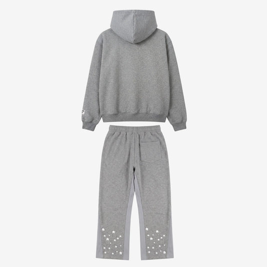 Back view flat-lay photograph of the CELESTIC Grey Star Tracksuit on a white background. The set includes a premium heather grey pullover hoodie with a structured hood and a matching pair of sweatpants. The sweatpants feature light grey side panels and a single back pocket on the right. Both legs are detailed with multiple scattered white embroidered stars on the lower back portion. A woven brand patch is visible on the hoodie's left sleeve.