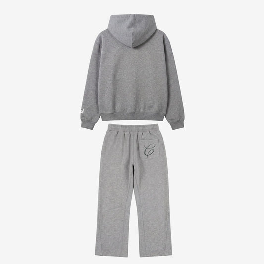 Back view flat-lay photograph of the CELESTIC Grey Zipper Tracksuit on a white background. The set includes a premium heather grey zip-up hoodie with a structured hood and a woven brand patch on the left sleeve cuff. The matching relaxed-fit sweatpants feature a single back pocket on the right side, detailed with an elegant black embroidered 'C' script logo.