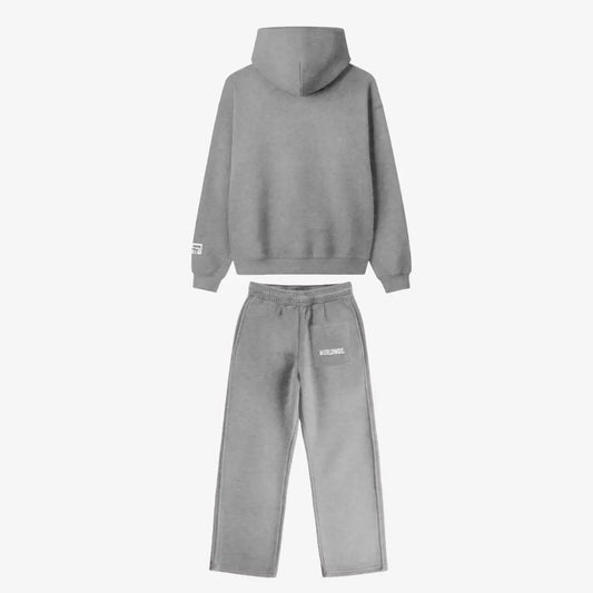 Back view of the full CELESTIC Grey Basic Tracksuit set laid flat on a white background. This premium heavyweight grey cotton fleece ensemble features an oversized zip-up hoodie with a structured hood and matching relaxed straight-leg sweatpants with white 'WORLDWIDE' embroidery on the back pocket.