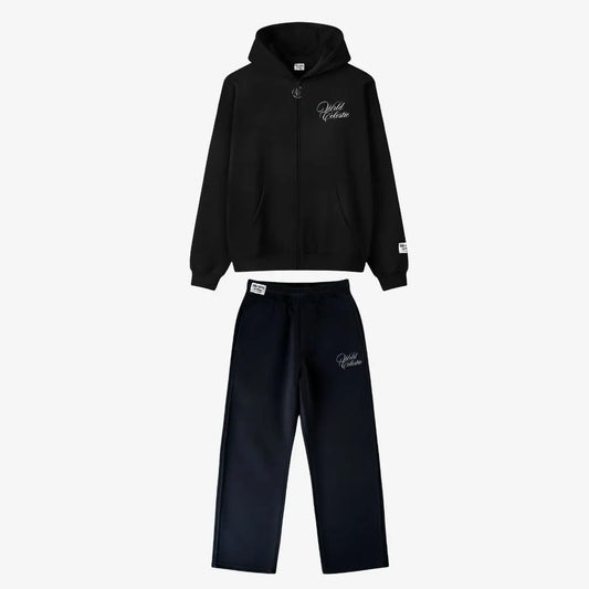 Main product image of the CELESTIC Black Basic Tracksuit set. This premium heavyweight black cotton fleece ensemble includes an oversized full-zip hoodie with white script logo embroidery on the chest, a custom metal 'C' zipper pull, and matching relaxed straight-leg sweatpants with thigh embroidery and a branded elastic waistband.
