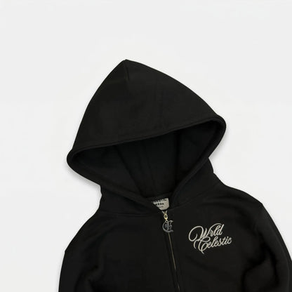 Detailed close-up of the CELESTIC Black Basic zip-up hoodie upper section. Highlighting the structured double-lined hood, premium heavyweight black cotton fleece, white script logo embroidery on the chest, and the custom metal 'C' zipper pull.