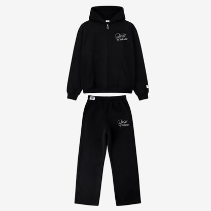 Main product image of the CELESTIC Black Basic Tracksuit set. This premium heavyweight black cotton fleece ensemble includes an oversized full-zip hoodie with white script logo embroidery on the chest, a custom metal 'C' zipper pull, and matching relaxed straight-leg sweatpants with thigh embroidery and a branded elastic waistband.