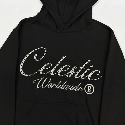 Detailed close-up photograph of the CELESTIC Black Gemstone Hoodie. The focus is on the chest, showcasing the premium heavyweight black cotton fleece and the large white screen-printed 'Celestic' script logo, heavily detailed with sparkling rhinestones. The white printed text 'Worldwide ®' is clearly visible below the script. The base of the structured hood and the top of the kangaroo pocket frame the logo.