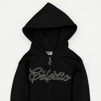 Black oversized zip-up hoodie detailed close-up view on model. Highlights include the full-length metal zipper, spacious front kangaroo-style pockets, and the ribbed hem and cuff structure. The premium heavyweight fleece cotton texture is clearly visible against a concrete background.