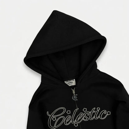 Black oversized zip-up hoodie detailed close-up of the hood and chest. Highlighting the structured double-lined hood, custom metal 'C' logo zipper pull, inner neck brand label, and the signature Celestic white outline embroidery with star accents on premium heavyweight fleece.
