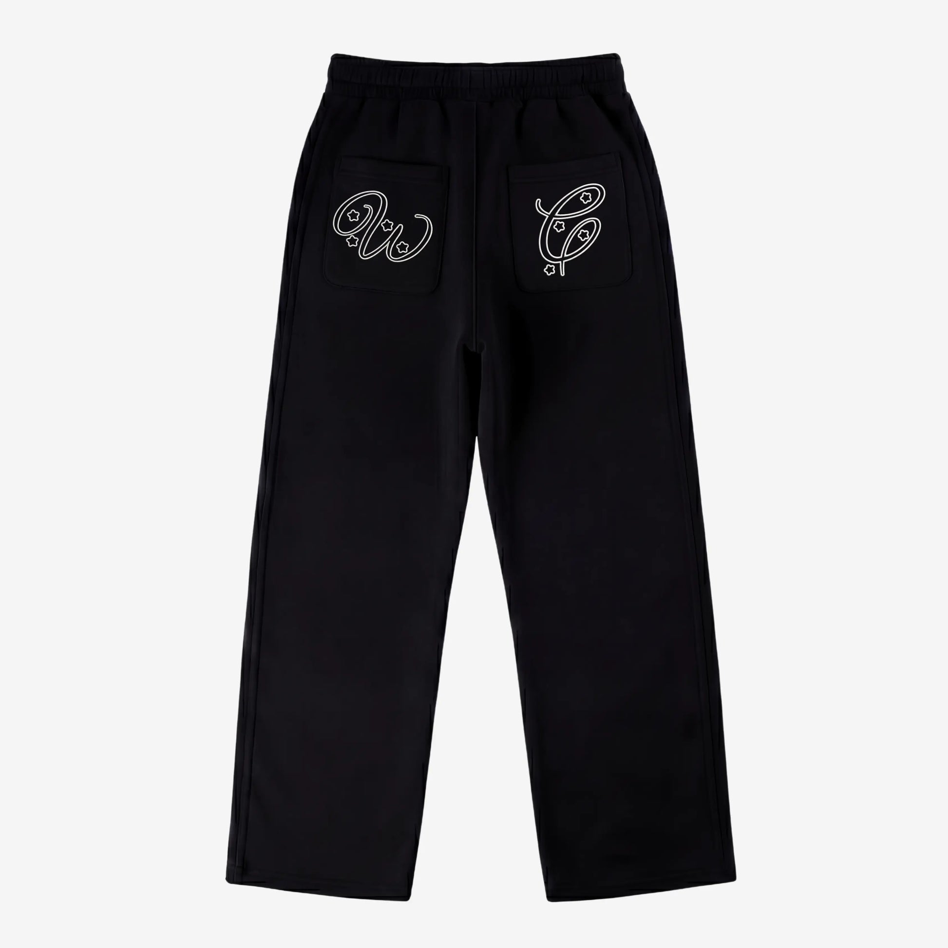 Black oversized tracksuit sweatpants back view laid flat on a white background. The premium heavyweight cotton fleece pants feature an elasticated waistband and custom white outline logo embroidery with star accents on both back pockets.