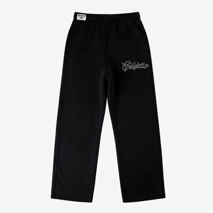 Black oversized tracksuit sweatpants laid flat on a white background. The premium heavyweight cotton fleece pants feature an elasticated waistband with a woven Celestic brand label, and the signature white outline logo embroidery with star accents on the left thigh.