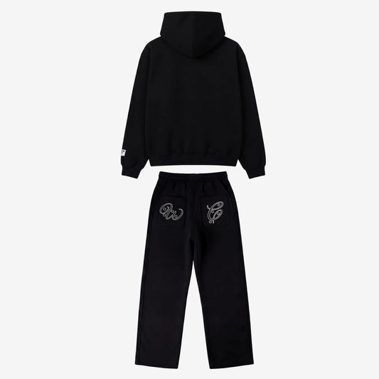 Black oversized tracksuit back view. Premium heavyweight cotton fleece two-piece set featuring a hoodie and matching sweatpants with white outline embroidery on the back pockets.