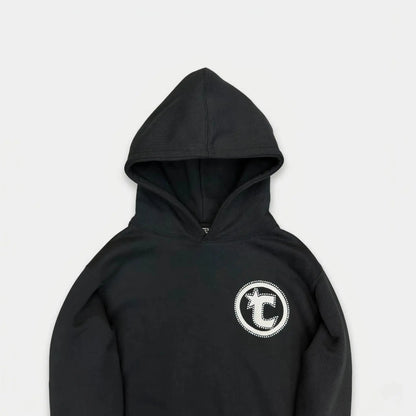 Detailed close-up of the CELESTIC Black Star hoodie upper section. Highlighting the premium heavyweight black cotton fleece fabric, the structured double-lined hood, and the prominent white circular 'C' star logo embroidery on the chest.