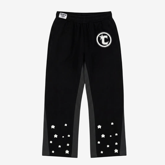 Front view flat-lay photograph of the CELESTIC Black Star Pants on a white background. These premium heavyweight black cotton fleece sweatpants feature a relaxed straight-leg fit, contrasting grey side panels, and multiple scattered white embroidered stars on the lower legs. Details include a prominent white circular 'C' star logo embroidery on the left thigh and a woven CELESTIC brand label on the elastic waistband.