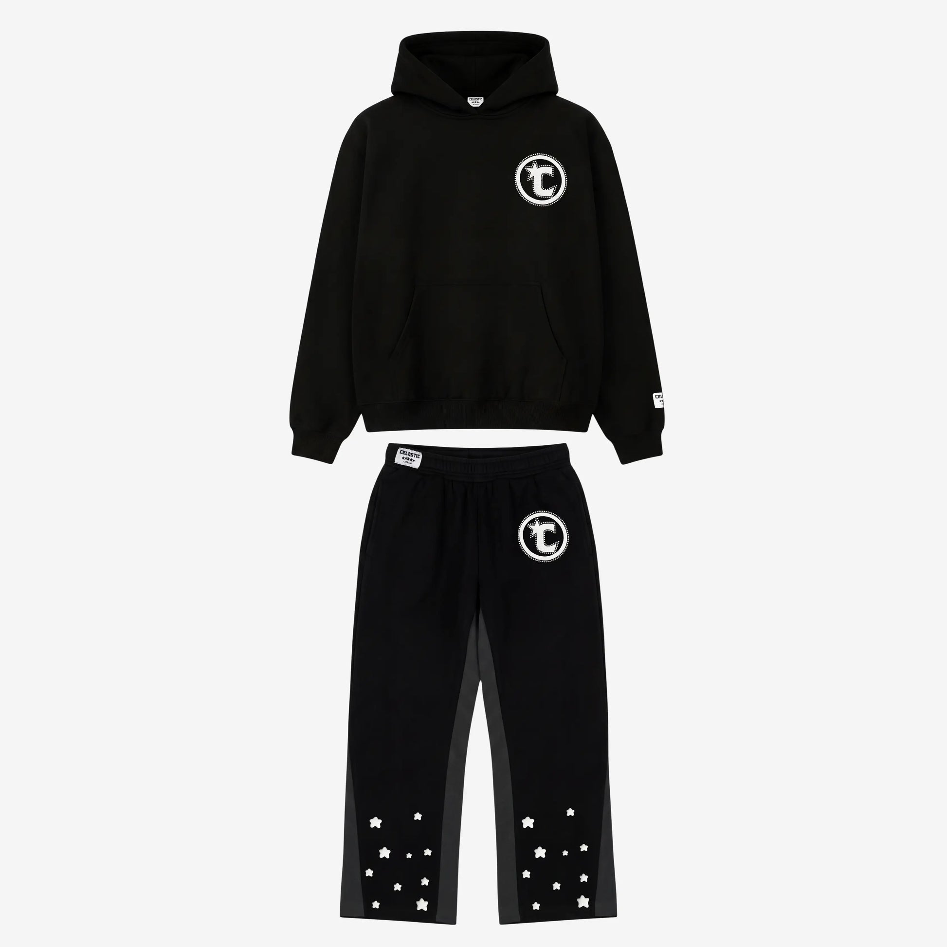 Main product image of the CELESTIC Black Star Tracksuit set. This premium heavyweight black cotton fleece ensemble features an oversized hoodie with a white circular 'C' star logo on the chest and matching relaxed sweatpants with the same logo on the thigh and multiple white embroidered stars at the leg openings. 