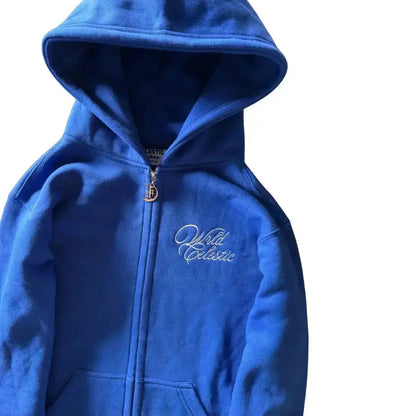 Detailed close-up view of the CELESTIC Blue Basic zip-up hoodie. Highlighting the premium heavyweight blue cotton fleece fabric, the structured hood, the elegant white script logo embroidery on the chest, and the custom metal 'C' zipper pull.