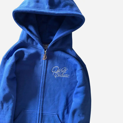 Detailed close-up view of the CELESTIC Blue Basic zip-up hoodie. Highlighting the premium heavyweight blue cotton fleece fabric, the structured hood, the elegant white script logo embroidery on the chest, and the custom metal 'C' zipper pull.