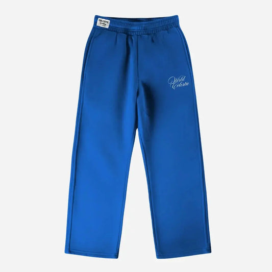 Blue oversized tracksuit sweatpants front view laid flat on a white background. The premium heavyweight cotton fleece CELESTIC Blue Basic pants feature an elasticated ribbed waistband with a woven brand label, prominent side seams, and elegant white script logo embroidery on the left thigh.