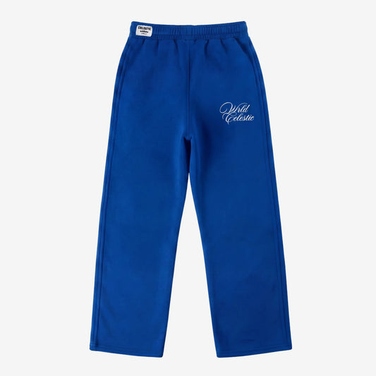 Blue oversized tracksuit sweatpants front view laid flat on a white background. The premium heavyweight cotton fleece CELESTIC Blue Basic pants feature an elasticated ribbed waistband with a woven brand label, prominent side seams, and elegant white script logo embroidery on the left thigh.