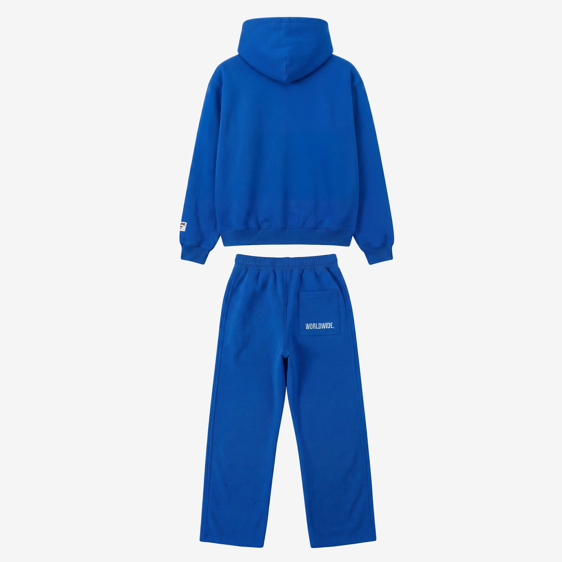 Back view of the CELESTIC Blue Basic Tracksuit laid flat on a white background. Premium heavyweight blue cotton fleece set showing a clean minimalist hoodie back, structured hood, and matching sweatpants featuring white 'WORLDWIDE' embroidery on the back pocket.