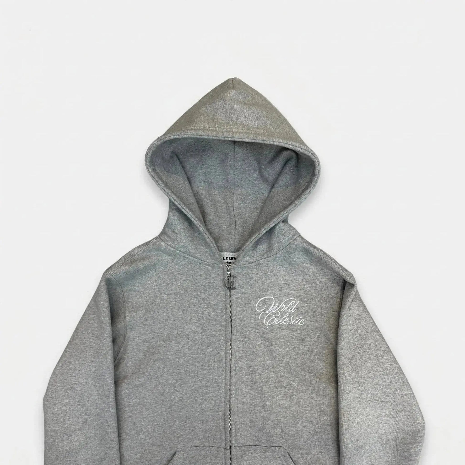 Detailed close-up view of the CELESTIC Grey Basic zip-up hoodie. Highlighting the premium heavyweight grey cotton fleece fabric, the structured double-lined hood, elegant white script logo embroidery on the chest, and the custom metal 'C' zipper pull.