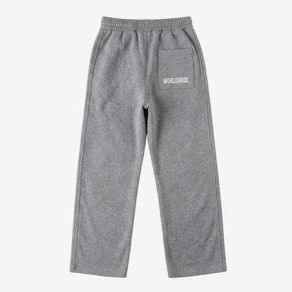 Back view of the CELESTIC Grey Basic sweatpants laid flat on a white background. These premium heavyweight grey cotton fleece pants feature a relaxed straight-leg silhouette and a back pocket with prominent white 'WORLDWIDE' logo embroidery.