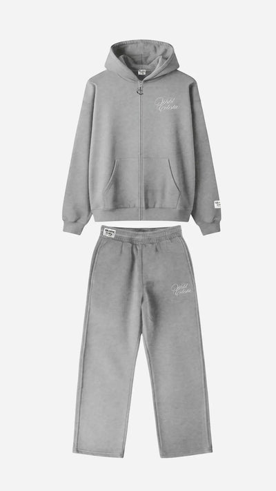 Main product image of the CELESTIC Grey Basic Tracksuit set. This premium heavyweight grey cotton fleece ensemble includes an oversized full-zip hoodie with white script logo embroidery on the chest, a custom metal 'C' zipper pull, and matching relaxed straight-leg sweatpants with thigh embroidery and a branded elastic waistband.