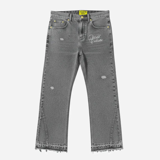Grey flared jeans front view. Premium washed distressed grey denim pants featuring lower leg panel stitching, frayed raw hems, subtle rips, and white Celestic embroidered logo on the thigh.