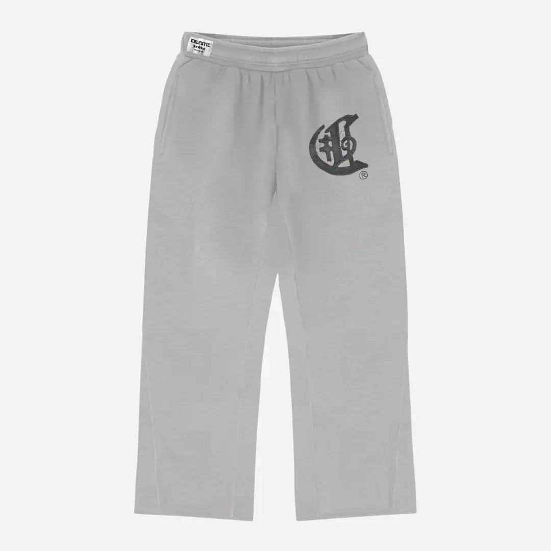 Front view flat-lay photograph of the CELESTIC Grey Zipper Flared Pants on a white background. These premium heather grey cotton fleece sweatpants feature a relaxed flared-leg fit, a comfortable elastic waistband, and side pockets. A large, prominent black gothic-style 'C' star logo is embroidered on the left thigh, and a white woven CELESTIC brand label is visible on the waistband.