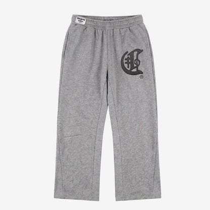 Front view flat-lay photograph of the CELESTIC Grey Zipper Flared Pants on a white background. These premium heather grey cotton fleece sweatpants feature a relaxed flared-leg fit, a comfortable elastic waistband, and side pockets. A large, prominent black gothic-style 'C' star logo is embroidered on the left thigh, and a white woven CELESTIC brand label is visible on the waistband.