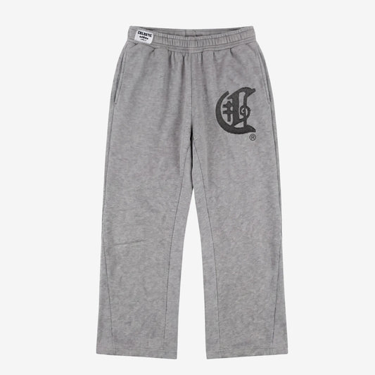 Front view flat-lay photograph of the CELESTIC Grey Zipper Flared Pants on a white background. These premium heather grey cotton fleece sweatpants feature a relaxed flared-leg fit, a comfortable elastic waistband, and side pockets. A large, prominent black gothic-style 'C' star logo is embroidered on the left thigh, and a white woven CELESTIC brand label is visible on the waistband.
