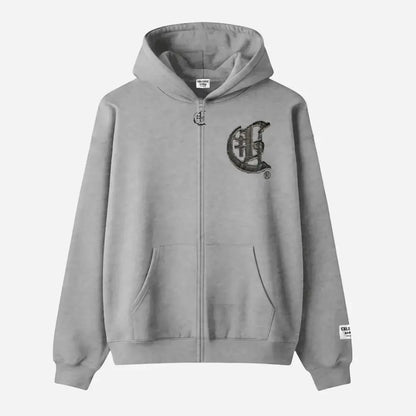 Front view flat-lay photograph of the CELESTIC Grey Zipper Hoodie on a white background. This premium heather grey cotton fleece zip-up hoodie features a silver-tone metal zipper, a spacious kangaroo pocket, and ribbed cuffs and hem. A large, distinctive black gothic-style 'C' star logo is embroidered on the left chest, and a white woven brand patch is visible on the left sleeve cuff.