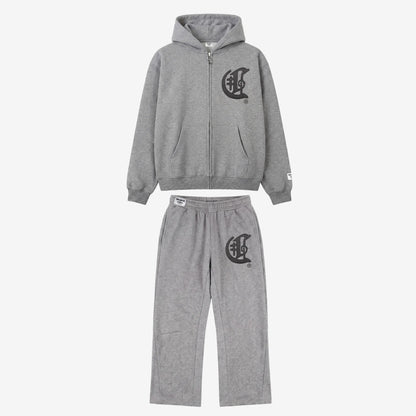 Full front view flat-lay photograph of the CELESTIC Grey Zipper Tracksuit on a white background. The set includes a premium heather grey zip-up hoodie with a kangaroo pocket and a matching pair of relaxed-fit sweatpants. Both pieces feature a large, distinctive black gothic-style 'C' star logo on the left chest and left thigh. The hoodie has a woven brand patch on the left sleeve, and the pants include a matching label on the waistband.