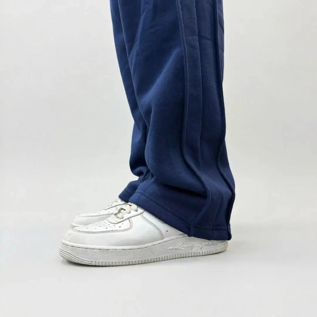 Detailed close-up view of the bottom leg on the CELESTIC Navy Blue Outline sweatpants. Highlighting the relaxed straight-leg hem, prominent side panel seams, and the premium heavyweight navy blue cotton fleece fabric resting on white sneakers.