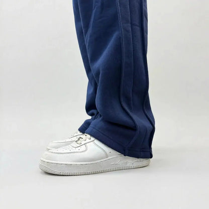 Detailed close-up view of the bottom leg on the CELESTIC Navy Blue Outline sweatpants. Highlighting the relaxed straight-leg hem, prominent side panel seams, and the premium heavyweight navy blue cotton fleece fabric resting on white sneakers.