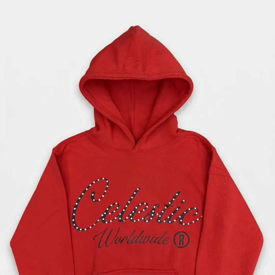 A detailed close-up flat-lay photograph of the upper section of the CELESTIC Red Gemstone Hoodie on a white background. Highlighting the premium vibrant red cotton fleece fabric and the structured double-lined hood. The chest features a large black screen-printed 'Celestic' script logo beautifully embellished with sparkling rhinestones, with the printed text 'Worldwide ®' situated underneath.