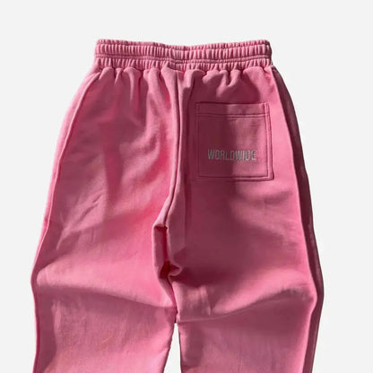 Detailed close-up of the back of the Celestic Pink Basic sweatpants. Highlighting the elasticated ribbed waistband, premium heavyweight pink fleece texture, and the right back pocket featuring white 'WORLDWIDE' embroidery.