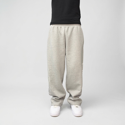 Front view on model of the CELESTIC Grey Script Pants in heavyweight heather grey cotton fleece, relaxed straight-leg fit over white sneakers.