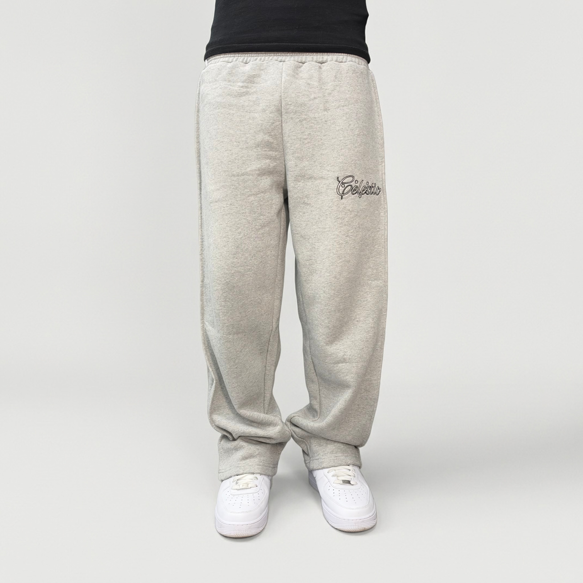 Front view on model of the CELESTIC Grey Outline Pants in heavyweight heather grey cotton fleece, with outline logo embroidery on the thigh.