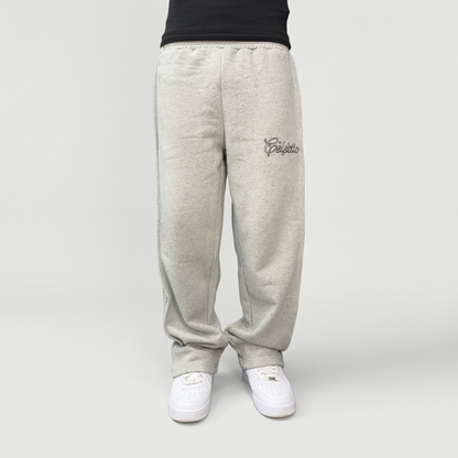 Front view on model of the CELESTIC Grey Outline Pants in heavyweight heather grey cotton fleece, with outline logo embroidery on the thigh.