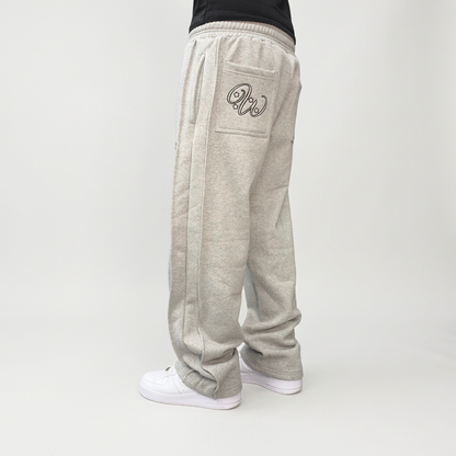 Back view on model of the CELESTIC Grey Outline Pants, showing the outline logo embroidery on the back pocket.
