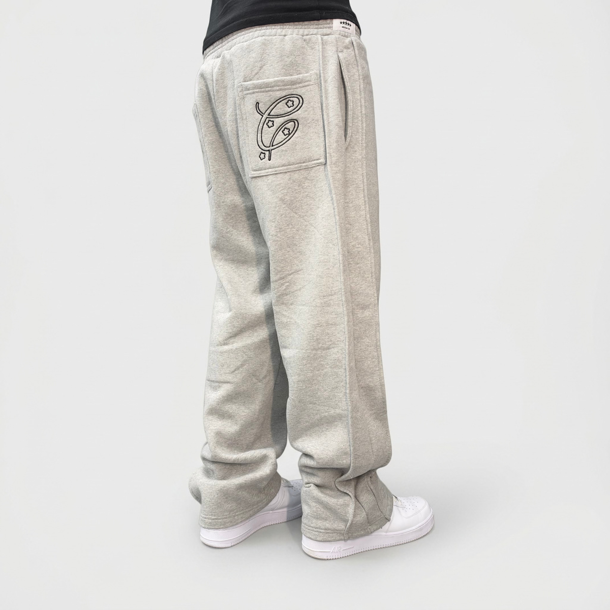 Back angle view of the CELESTIC Grey Outline Pants on model, highlighting the outline embroidery on the back pocket.