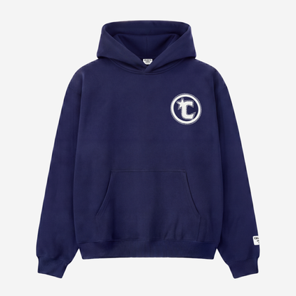 Front view of the CELESTIC Navy Blue Star Hoodie laid flat on a white background. Heavyweight navy blue cotton fleece pullover with a puff print circular C star logo and rhinestone outline on the chest, kangaroo pocket and woven brand patch on the sleeve.