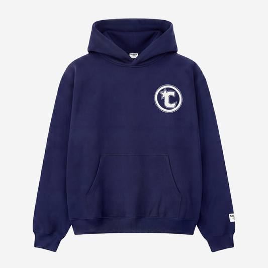 Front view of the CELESTIC Navy Blue Star Hoodie laid flat on a white background. Heavyweight navy blue cotton fleece pullover with a puff print circular C star logo and rhinestone outline on the chest, kangaroo pocket and woven brand patch on the sleeve.