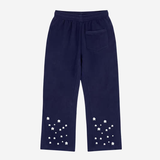 Back view of the CELESTIC Navy Blue Star Pants laid flat on a white background. Heavyweight navy blue cotton fleece flared sweatpants with embroidered stars around the leg openings and a woven CELESTIC label on the waistband.